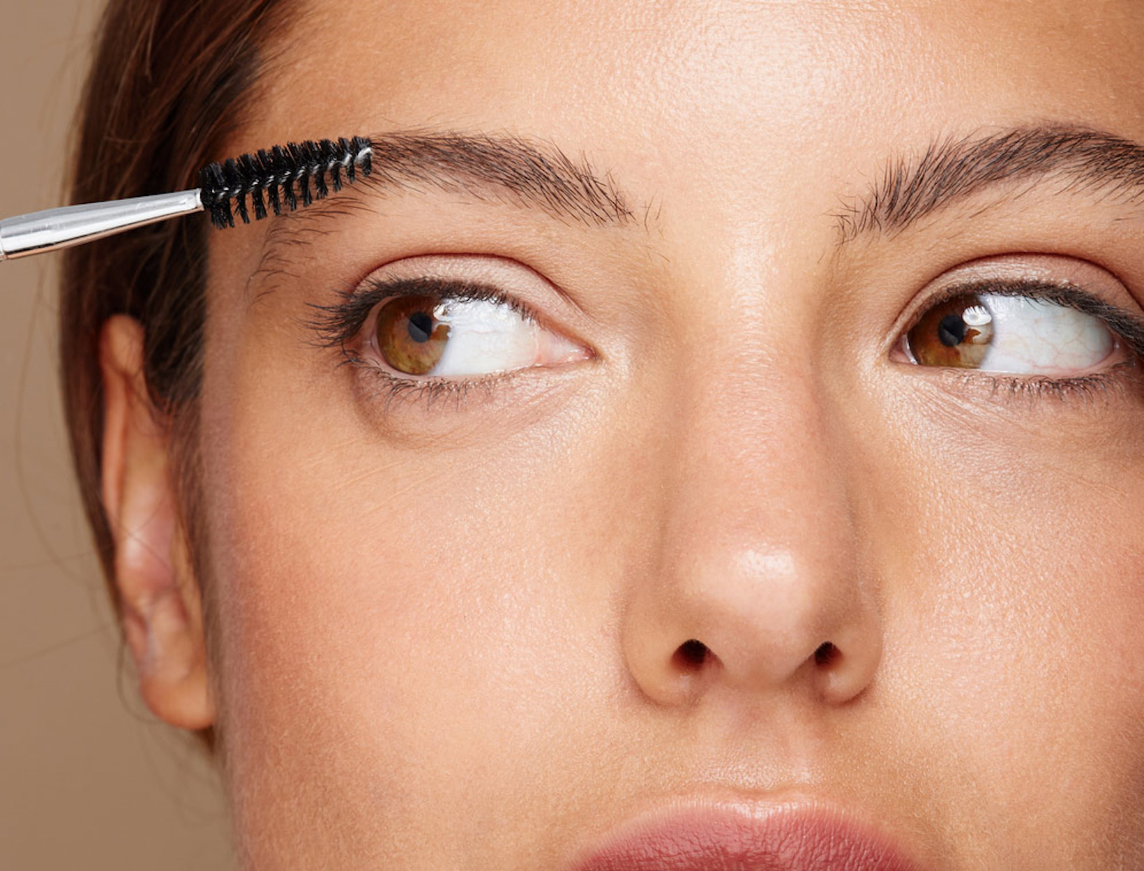 woman grooming her eyebrows