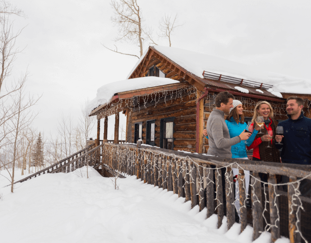 people smiling outside of a cabin