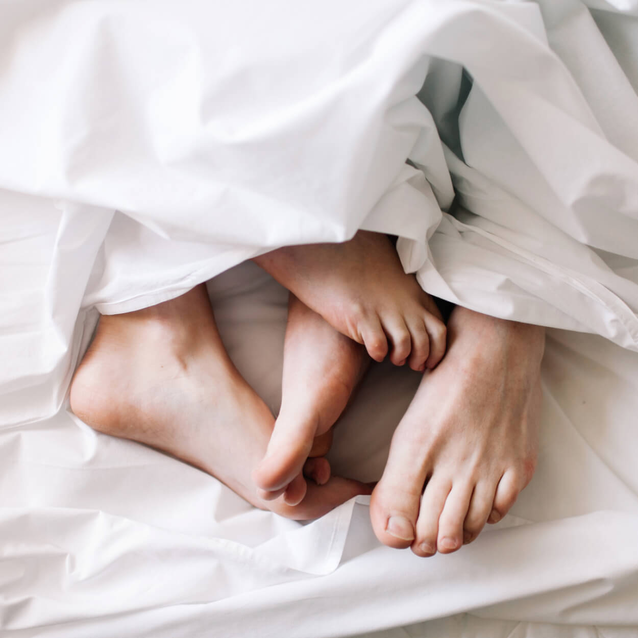 feet sticking out from under sheets