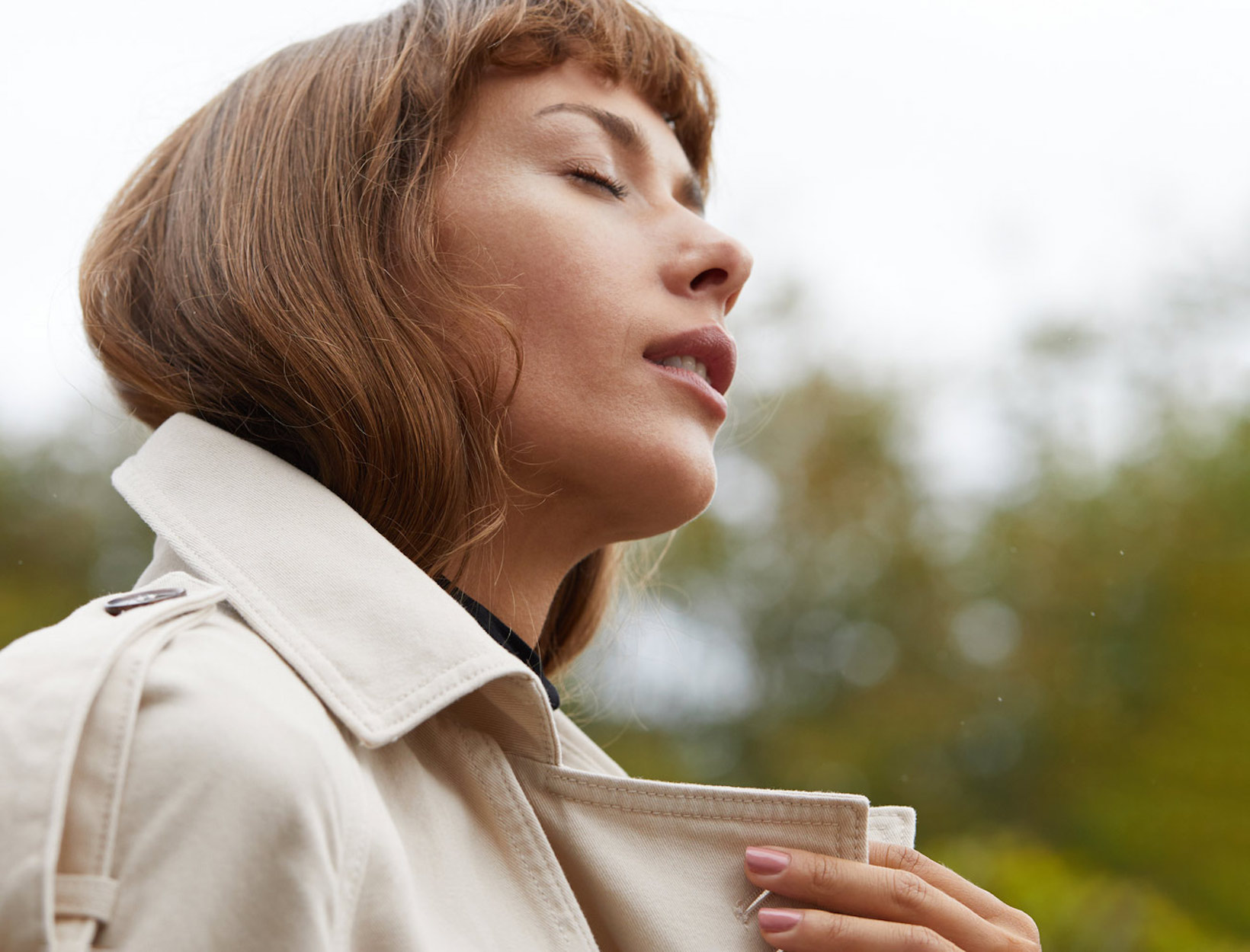 woman closing her eyes outside