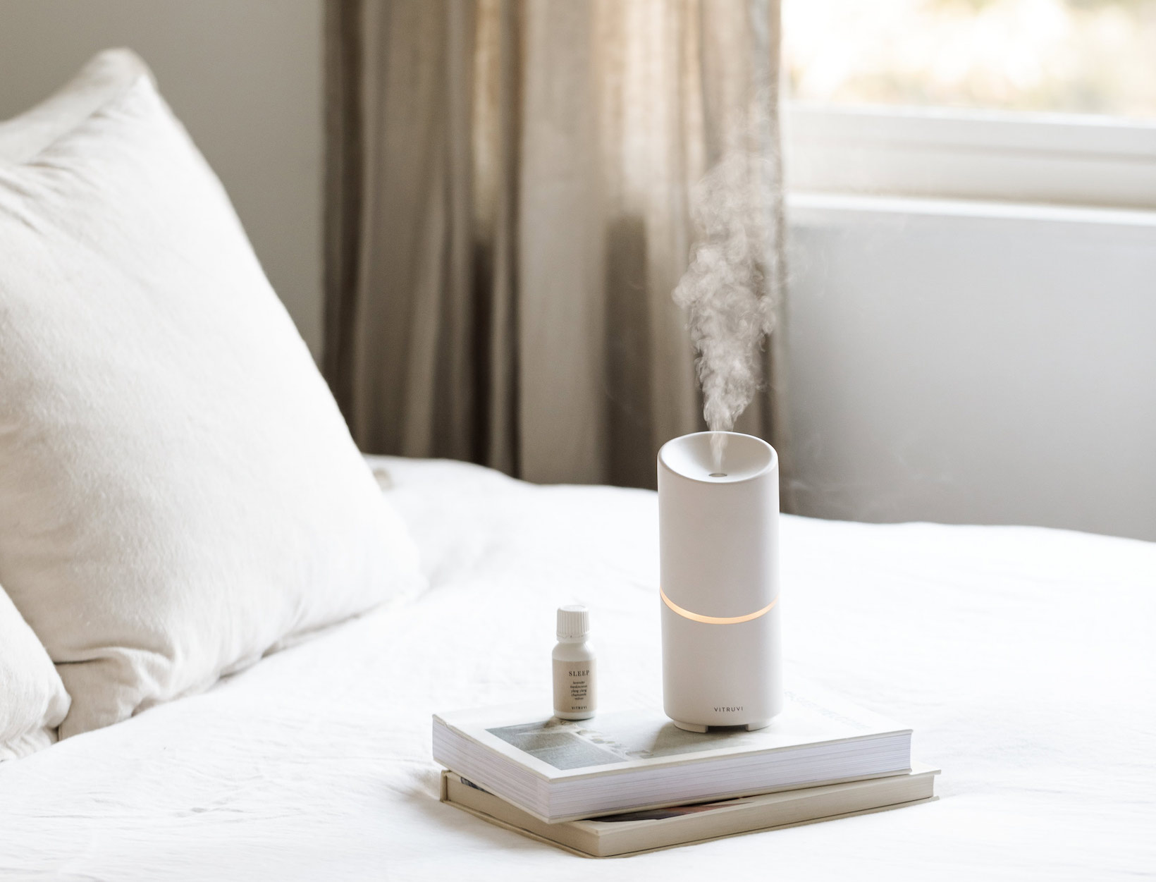 vitruvi diffuser on a bed