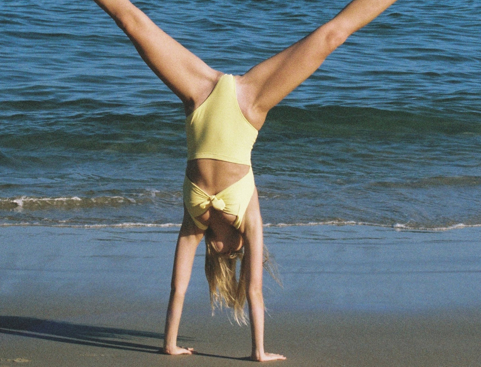 woman doing a cartwheel on the beach
