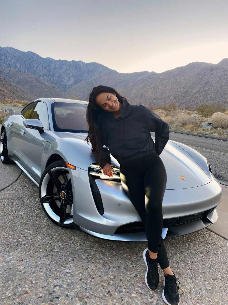 renee rupcich posing next to a porsche