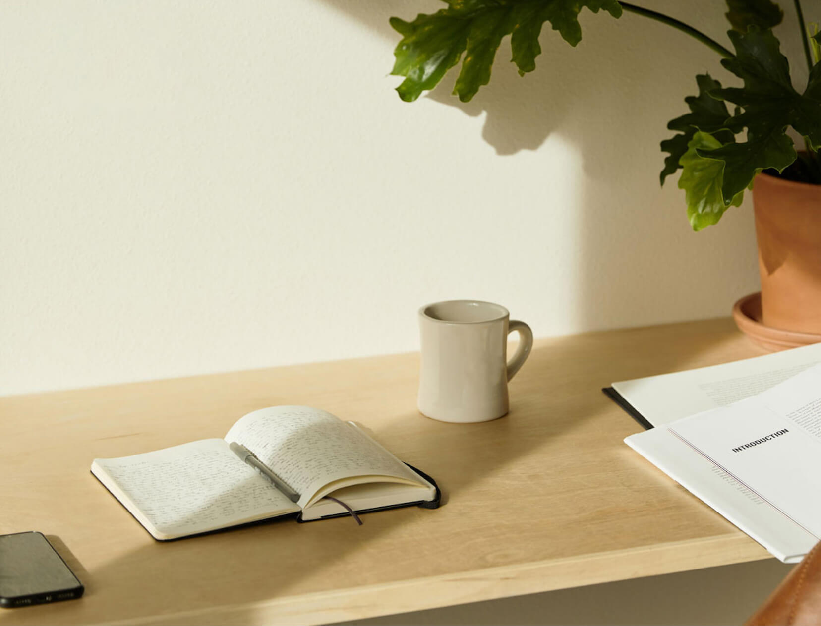 a coffee cup and a journal on a desk