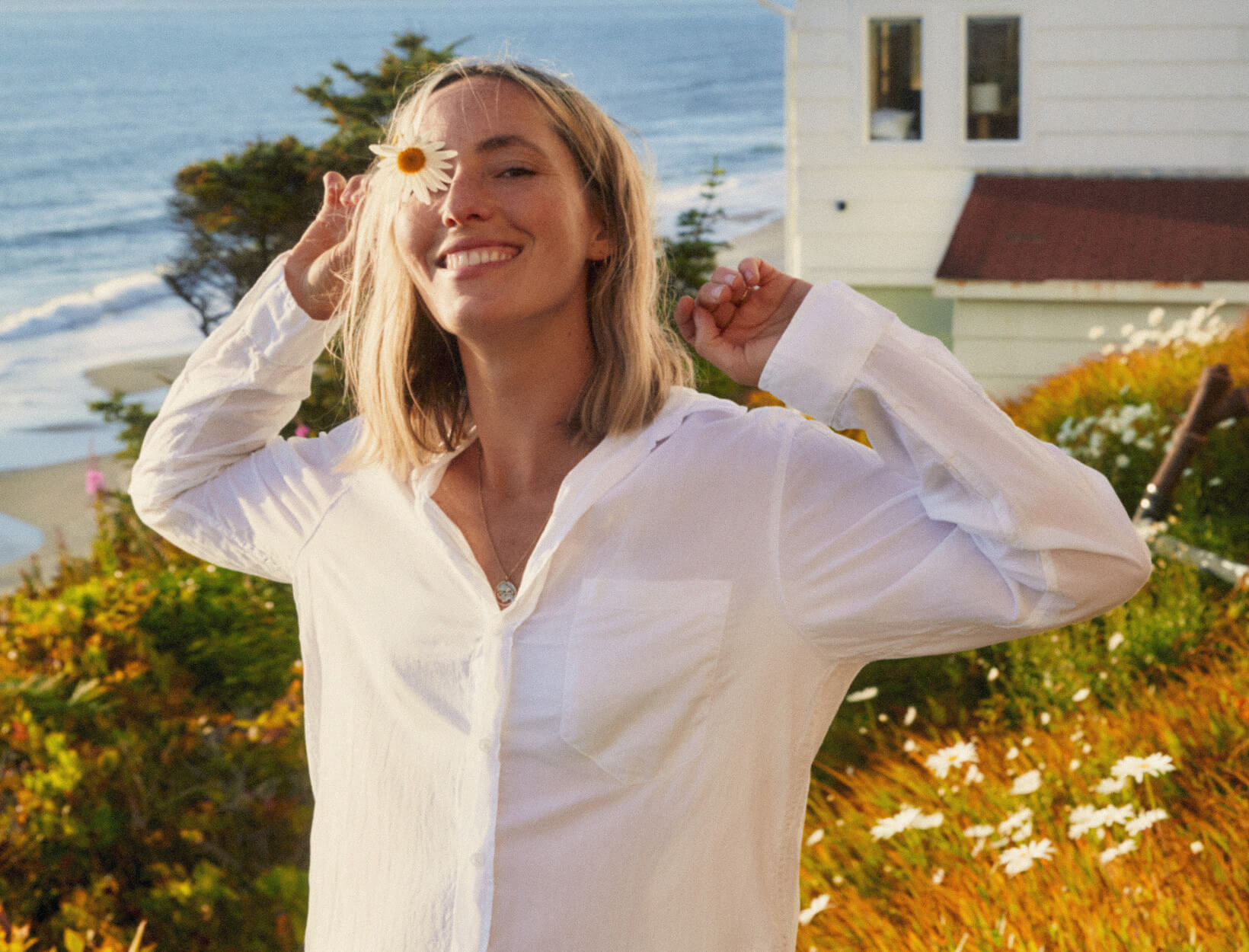 woman holding a daisy and smiling