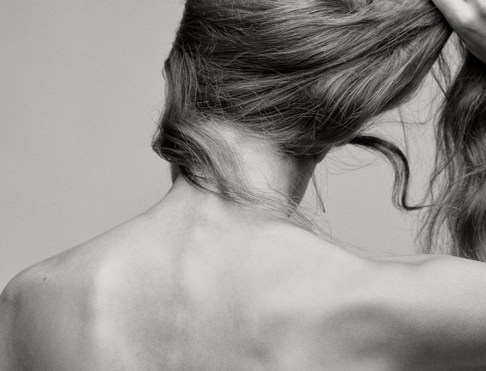 Sensual close-up of hair and bare shoulders in soft intimate lighting, dreamy relaxation mood